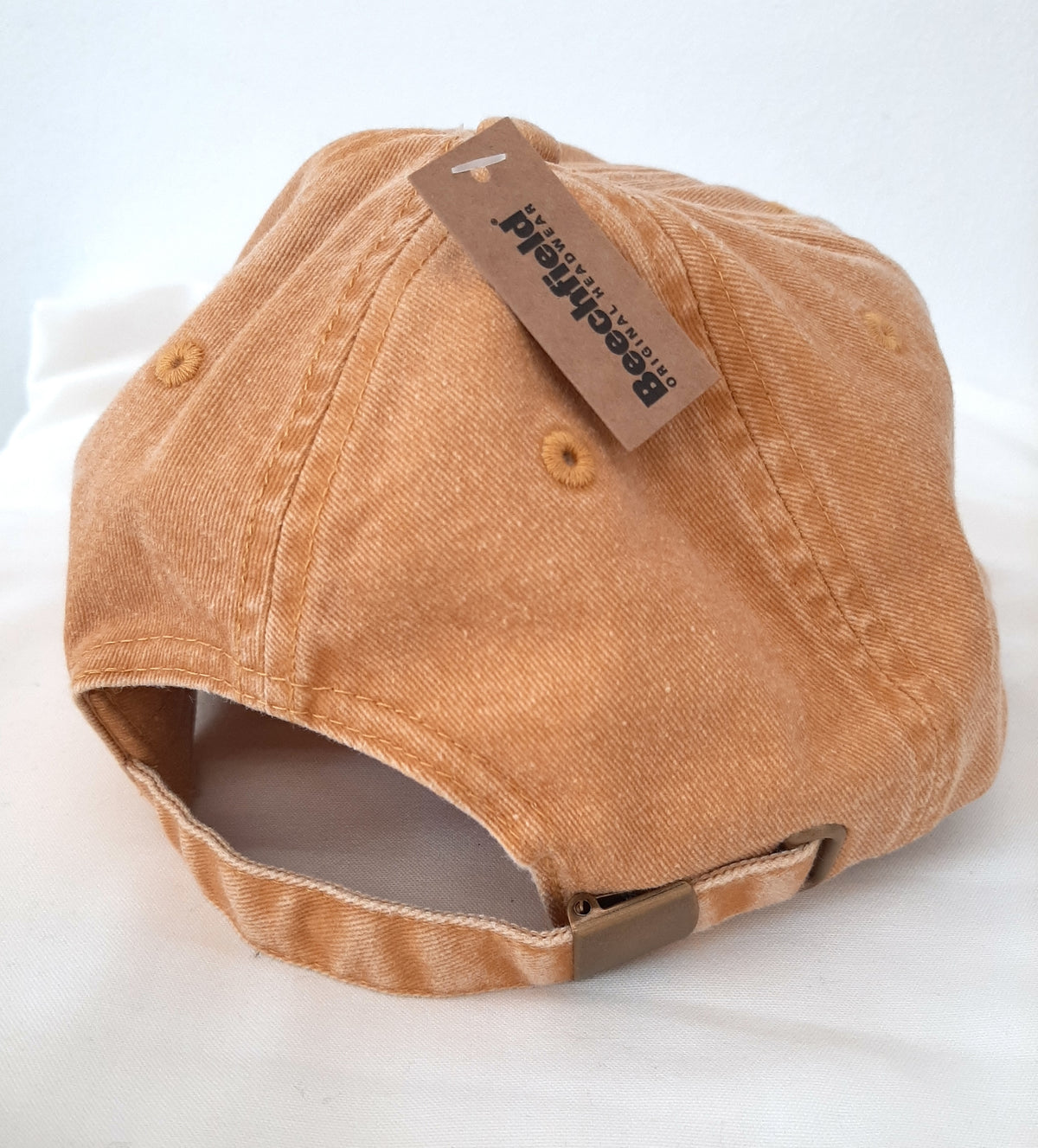 Back of vintage mustard artist cap by Kenji Lim.